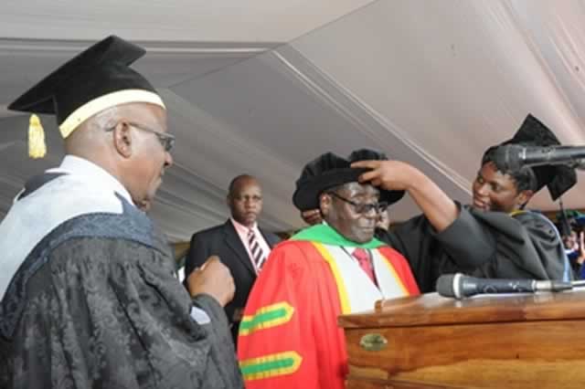President Mugabe receives the Honorary Doctorate of African Heritage and Philosophy from Great Zimbabwe University Vice Chancellor Professor Rungano Zvobgo. Here, an official from the university helps him don the regalia in Masvingo yesterday. — (Picture by Presidential Photographer Joseph Nyadzayo)