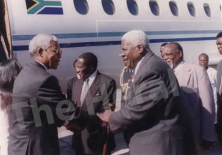 The late cde Nelson Mandela greets the late Vice President Joshua Nkomo at the Harare International Airport soon after his arrival in 1997. In the background are President Mugabe and the late Vice President Cde Simon Muzenda.