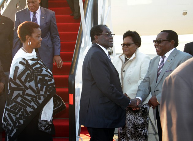 President Mugabe greets Zanu-PF National Chairman Simon Khaya Moyo, while the First Lady Amai Grace Mugabe awaits her turn as Vice President Dr Joice Mujuru looks on at the Harare International Airport yesterday.