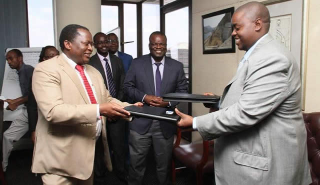 ZPC managing director Mr Noah Gwariro (left) and Intratrek managing director Wicknell Chivhayo exchange copies of the signed document for the construction of the 100 megawatt Gwanda power plant on Friday while ZPC projects and technical director Mr Robson Chikuri (centre) and other officials look on