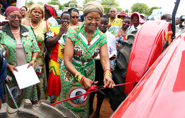 First Lady and zanu-pf Women’s League chairperson Amai Grace Mugabe cuts a ribbon to mark the official handover of farming implements to Matabeleland South Province at Maphisa Growth Point yesterday. Looking on is her deputy Cde Eunice Sandi Moyo (extreme left) and other revolutionary party officials. — (Picture by Eliah Saushoma)