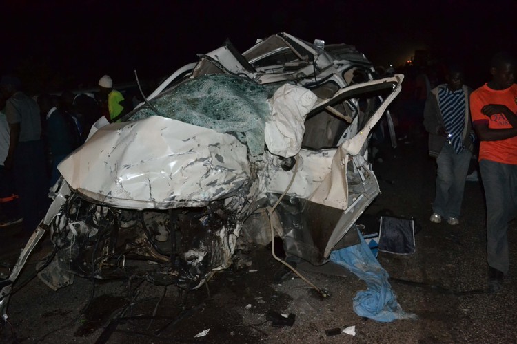 People view the mangled wreckage of a Toyota Regius which collided head-on with a Mutare-bound Nissan Caravan, resulting in the death of 15 people along Mutare-Chimanimani Road