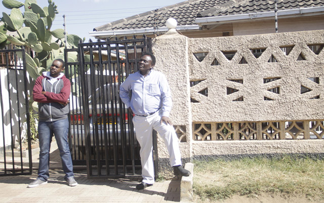 Chiundura Moyo outside his house with his son Tatenda