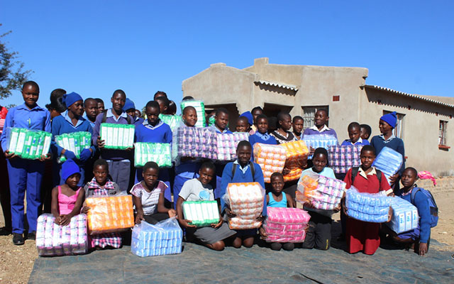 Beneficiaries pose for a group photo after receiving their sanitary wear