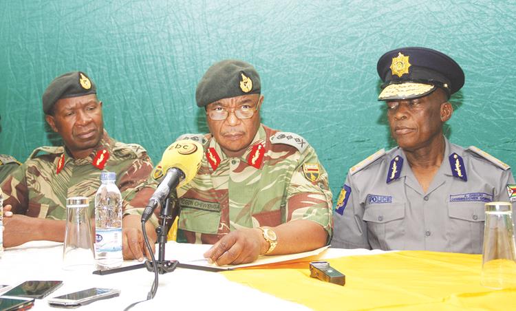 Zimbabwe Defence Forces Commander General Constantino Guveya Nyikadzino Chiwenga (centre) addresses a press conference at Army Headquarters last night. He is flanked by Zimbabwe National Army Commander Lieutenant-General Philip Valerio Sibanda (left) and Zimbabwe Republic Police Commissioner-General Augustine Chihuri. — Picture by John Manzongo