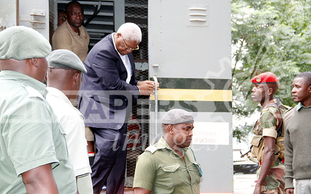 Former Minister of Finance Dr Ignatius Chombo being escorted into Harare Magistrates’ Courts under military police and prison security during his bail ruling yesterday. — Picture by John Manzongo