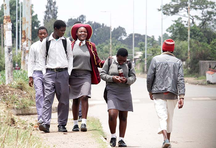 Secondary school children happily making their way home  after finishing their lessons in Harare.